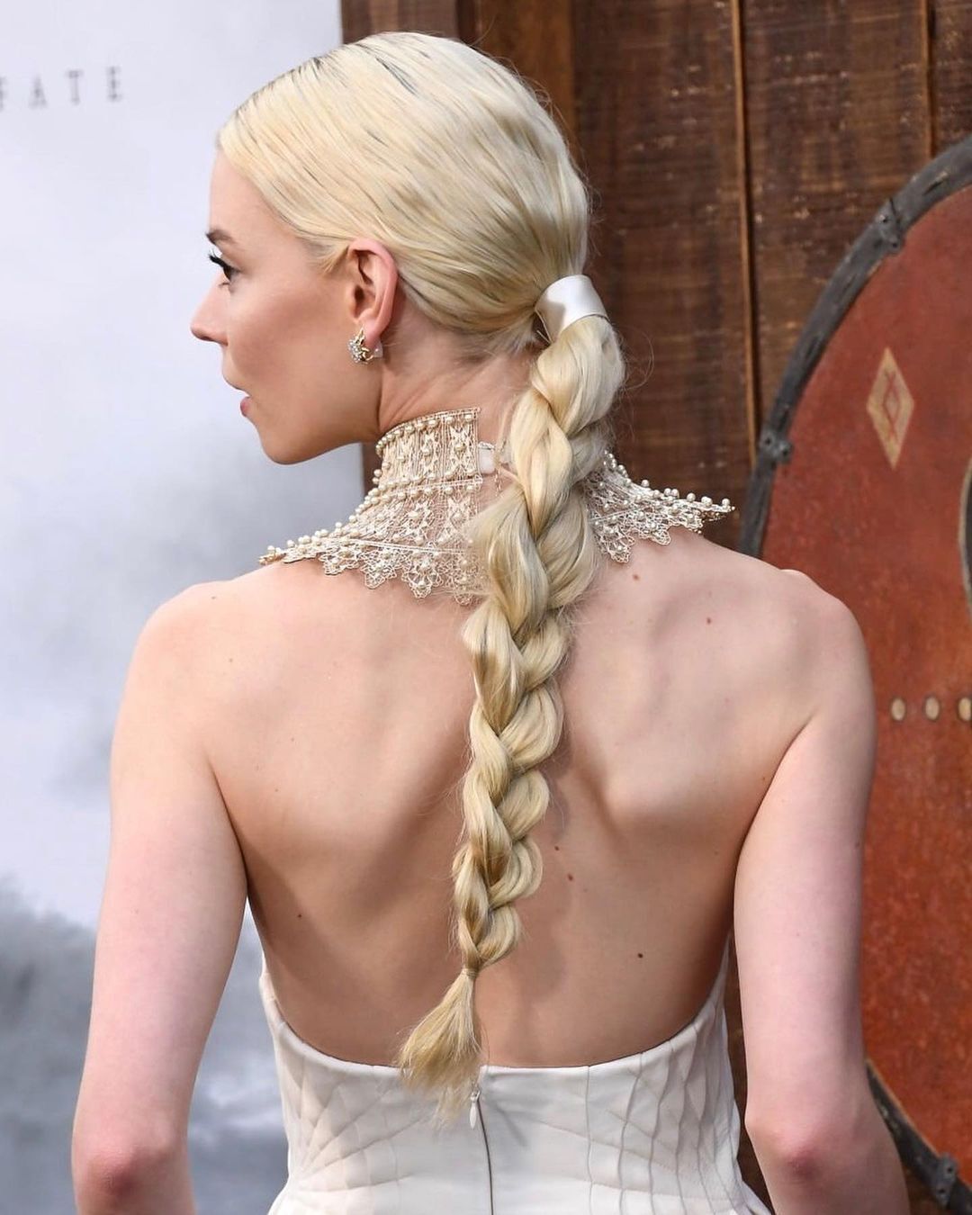 A portrait of Anya Taylor-Joy in a white dress at The Northman premiere.