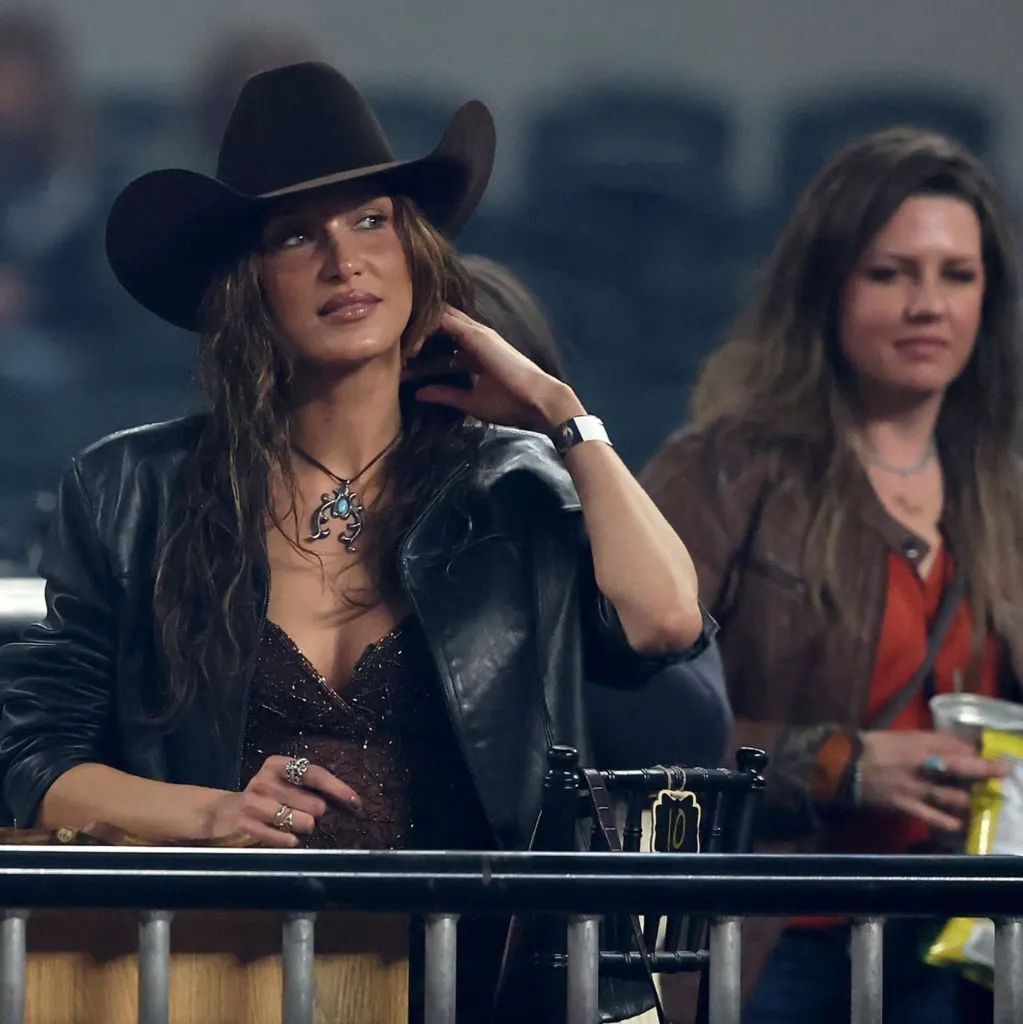 A portrait of Bella Hadid wearing a black cowboy hat and leather jacket.