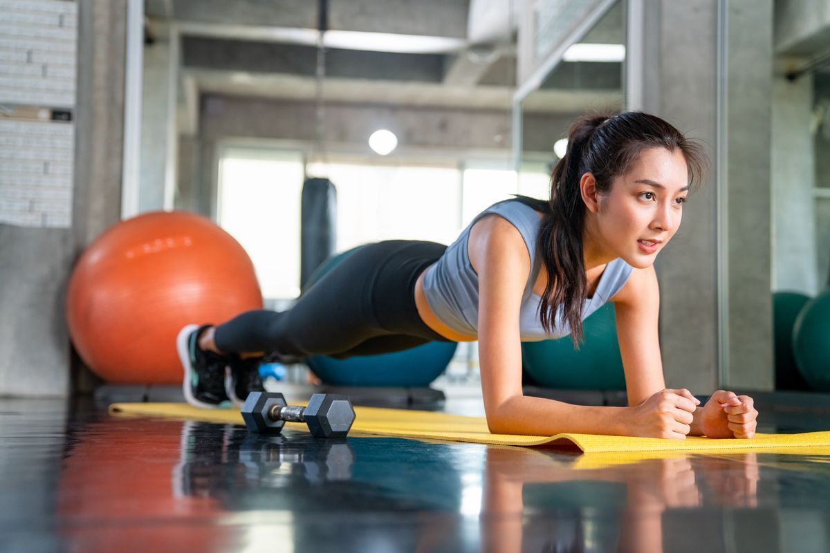 Woman doing a plank in a gym. 