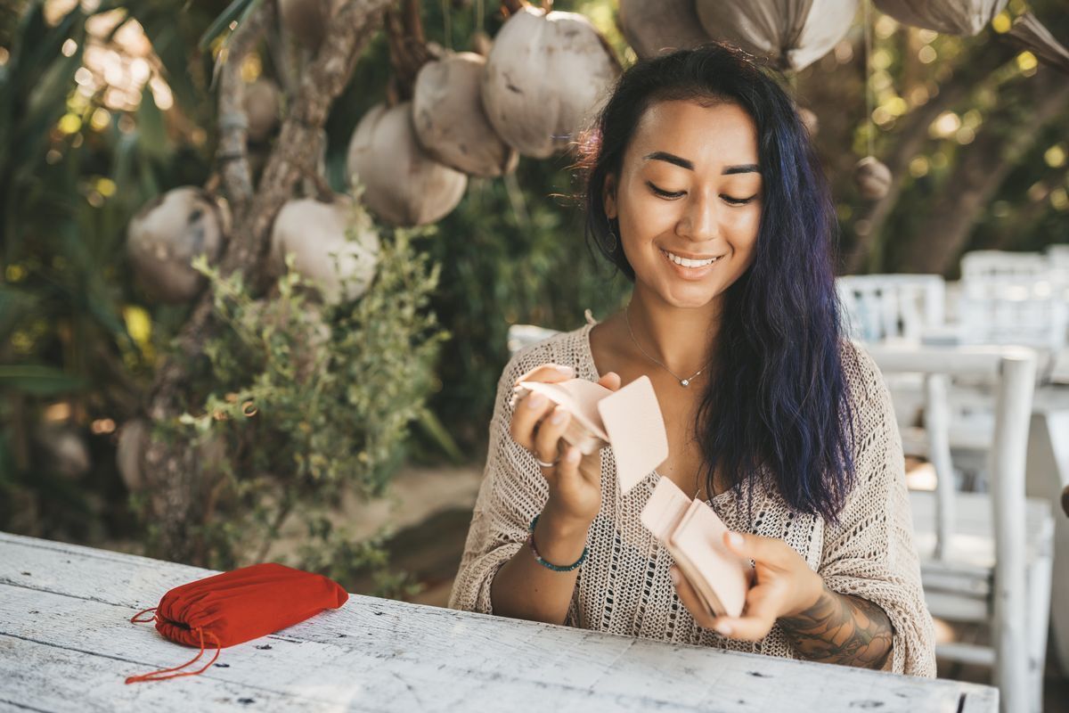 Asian woman playing with tarot cards.