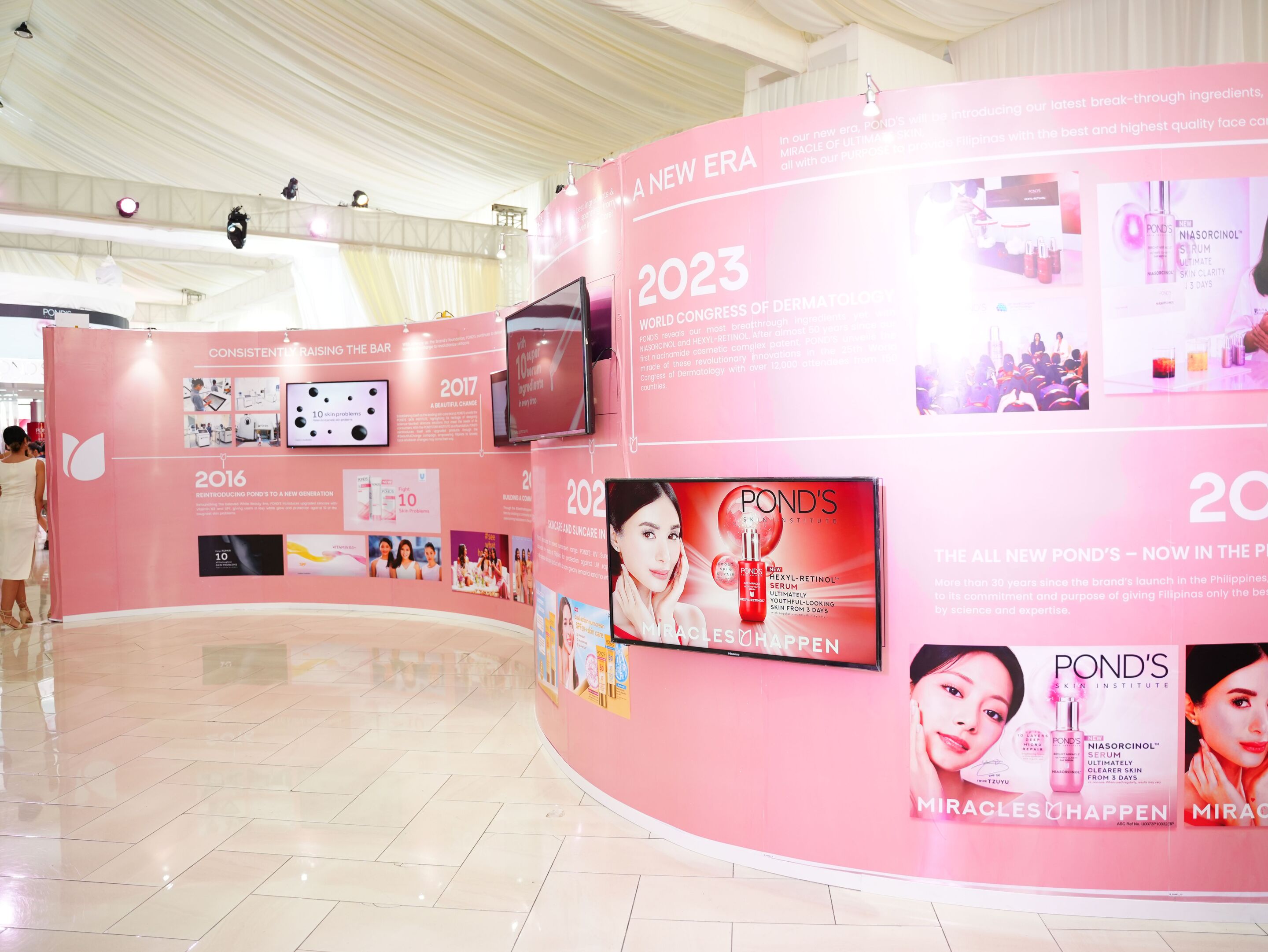 A pink photo wall of POND’s innovations through the years.