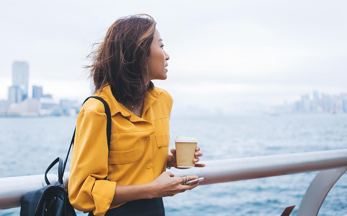 Asian woman in yellow looking at the horizon