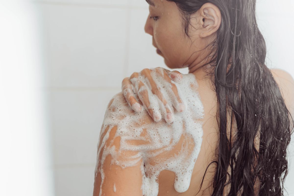 Asian woman taking a shower and using a body wash