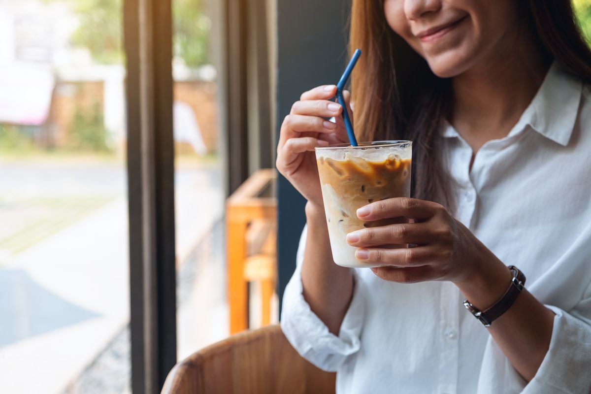 Woman drinking a cup of coffee at an office while working. 