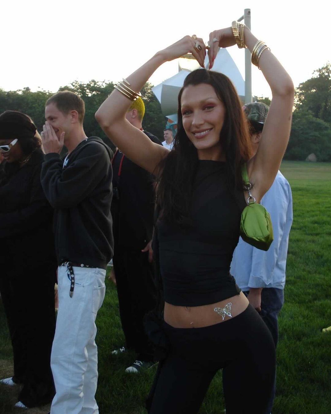A portrait of Bella Hadid with bumpit hair and sheer black top.