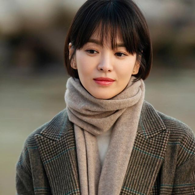 Song Hye Kyo wearing beige scarf and coat flaunting her apple cut hair.