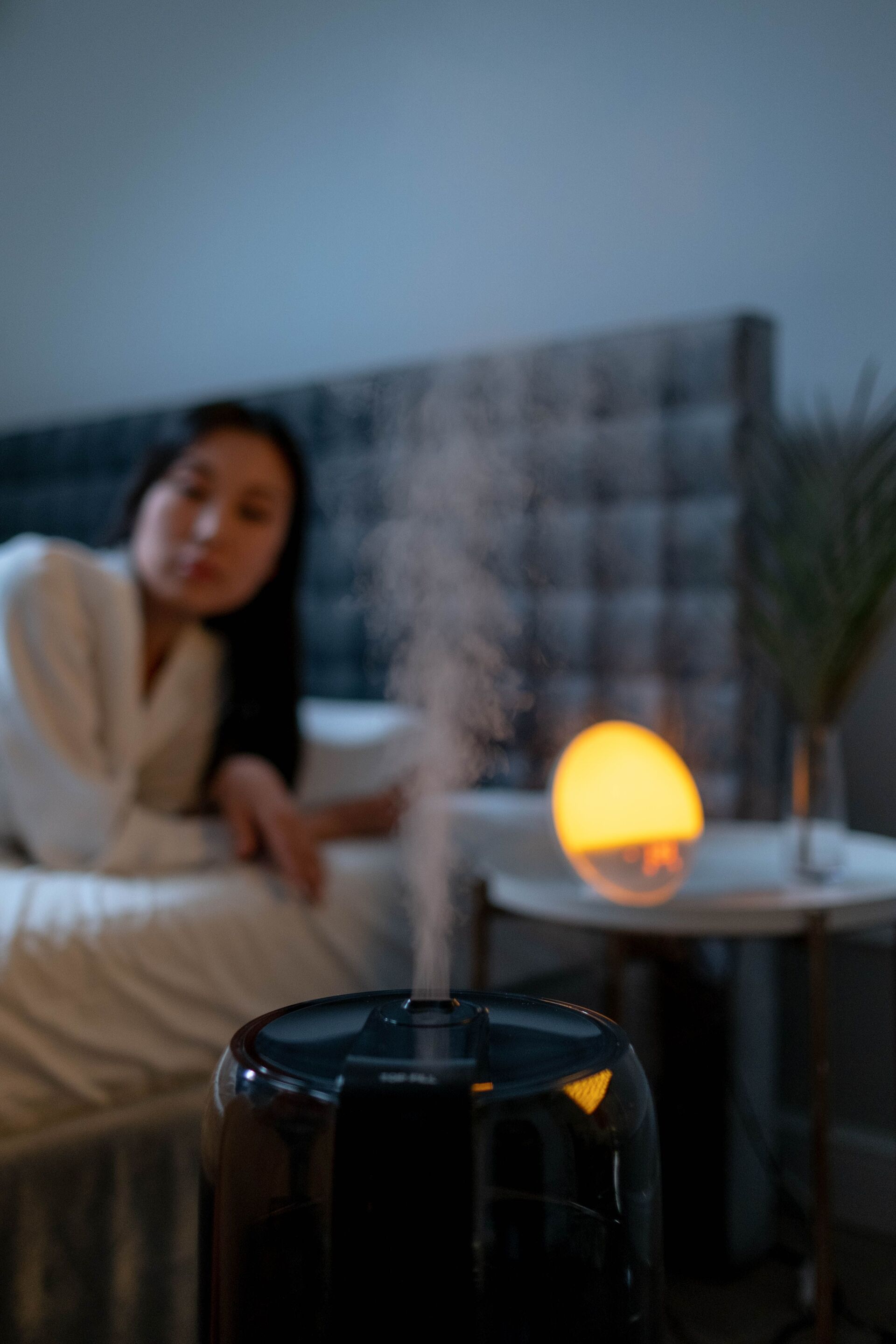 Asian woman readying for bed with black humidifier