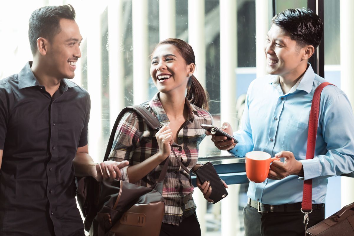 Two men and one woman talking together happily.