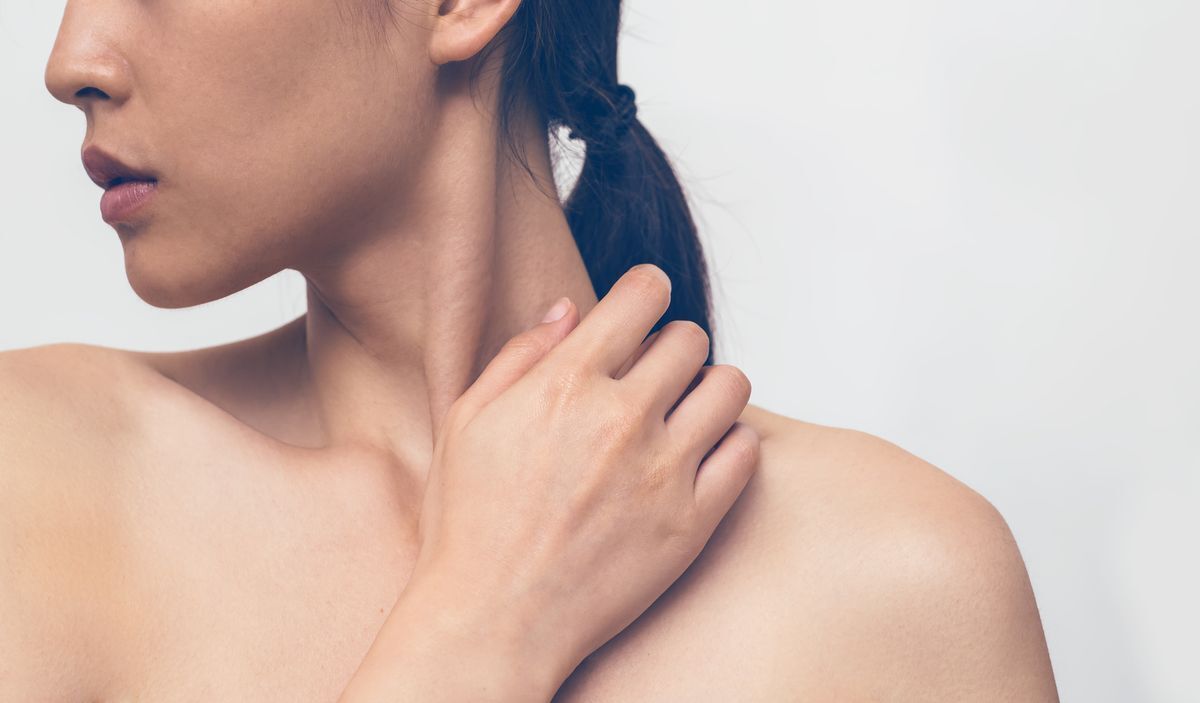 Woman scratching neck