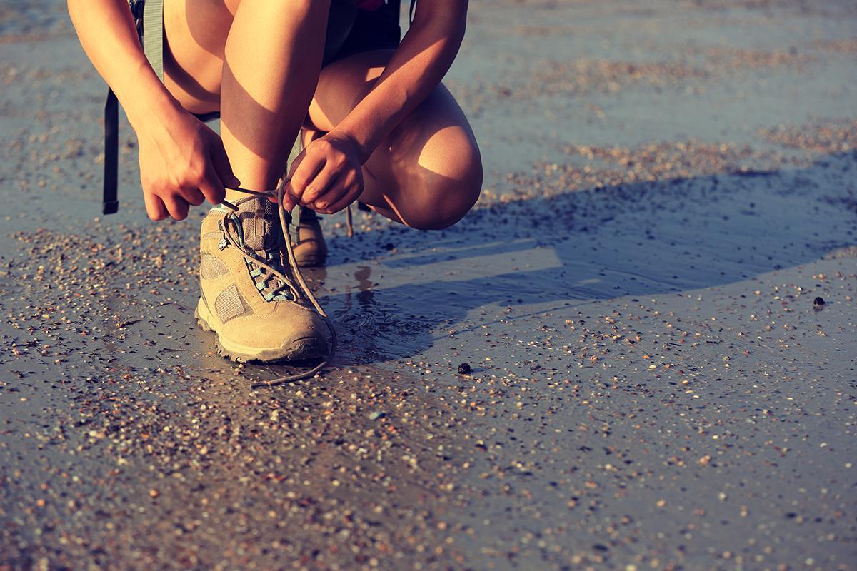 Asian hiker tying shoelaces