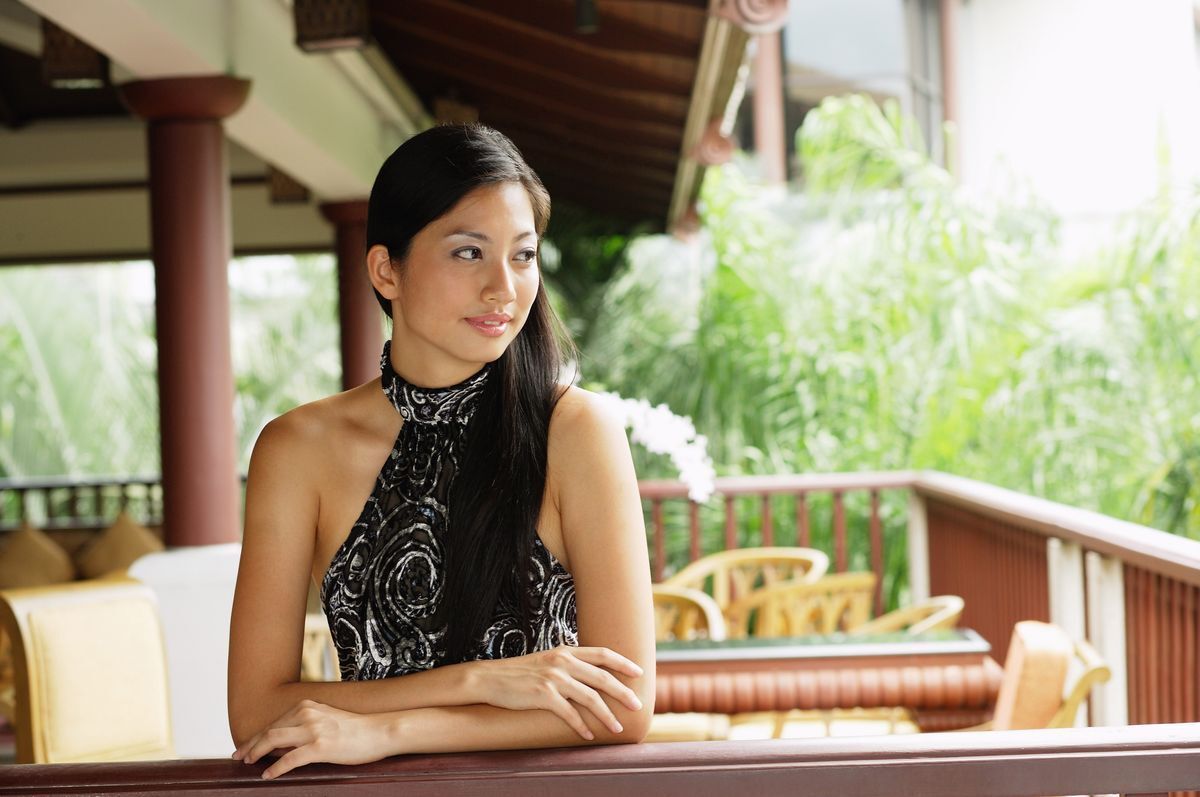 Fit Asian woman in a printed black halter top.
