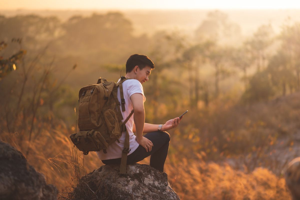 Asian man in nature with backpack