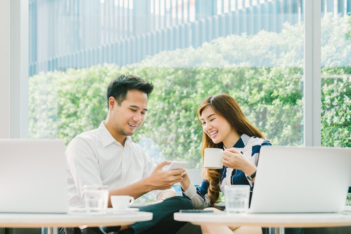 Asian man and woman discussing ideas while seated on the couch.