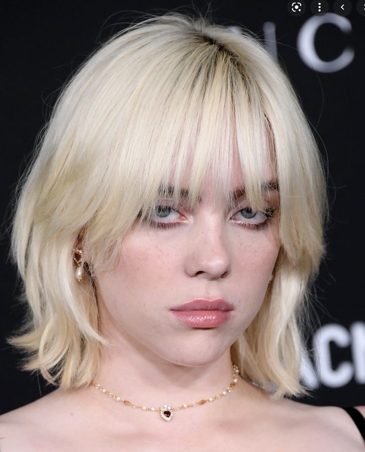 A portrait of Billie Eilish with blonde bullet bob.