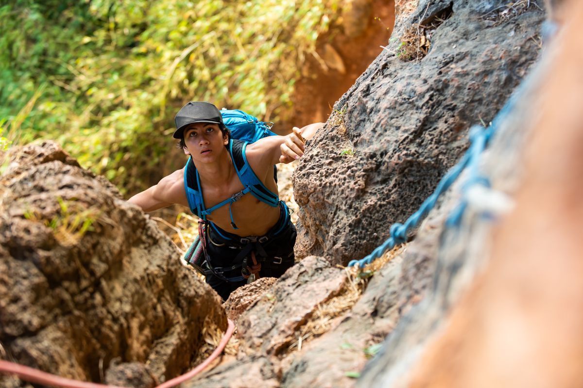 Asian man climbing rocks