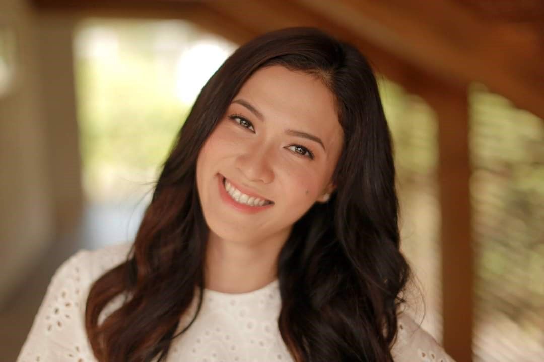 Closeup of woman in a white top smiling