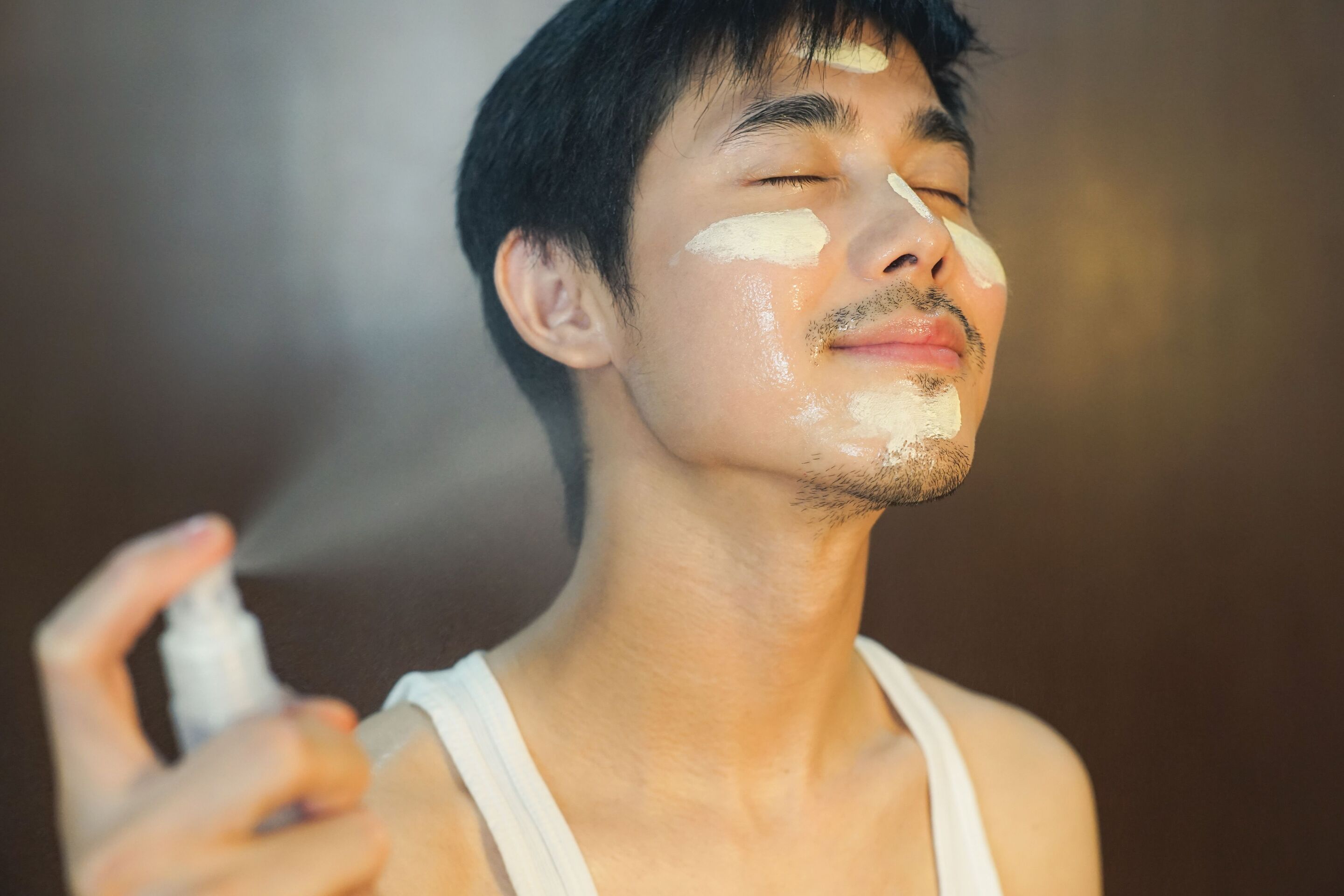 man applying moisturizer and sunscreen