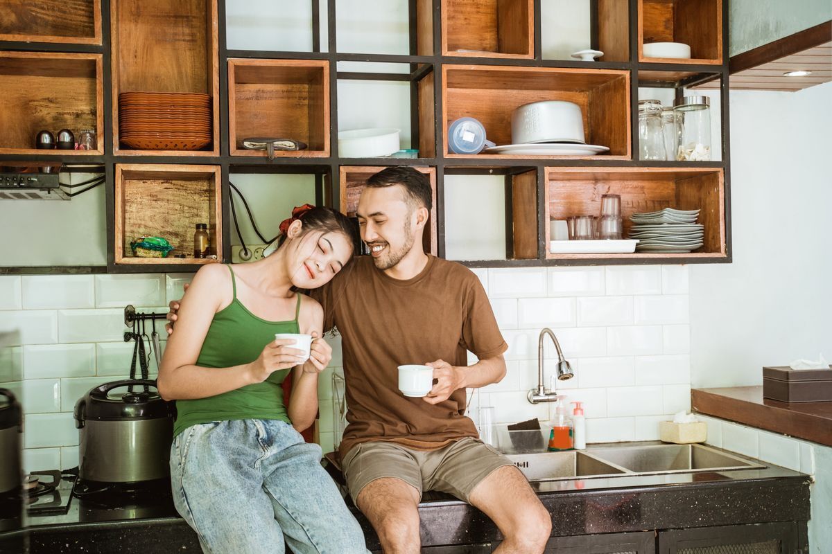 A couple sitting together on a kitchen counter.