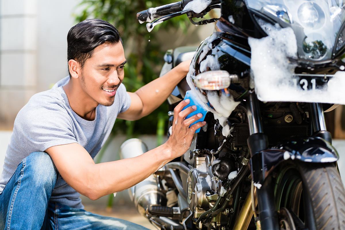 Asian man washing his motorcycle