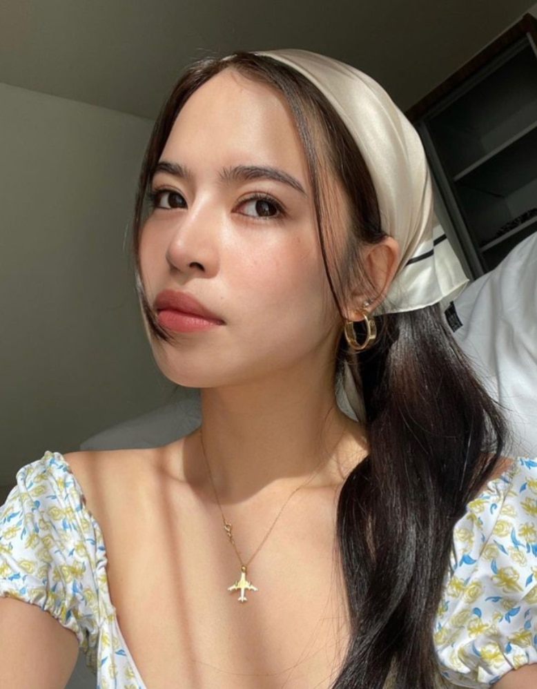 A woman wearing a silk hair bandana.