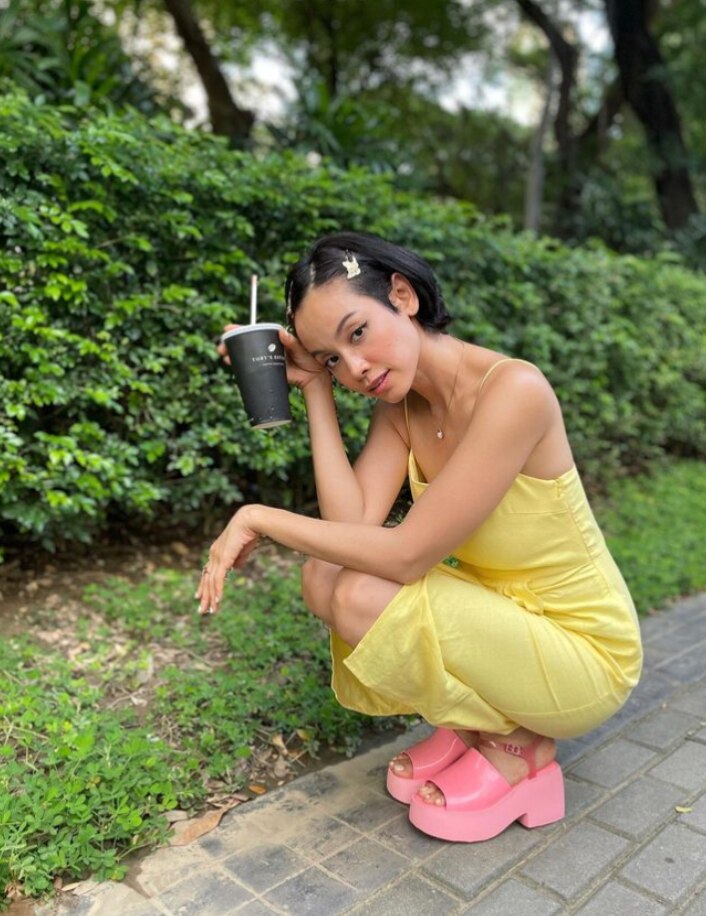 A woman in a yellow dress with matching hair clips.
