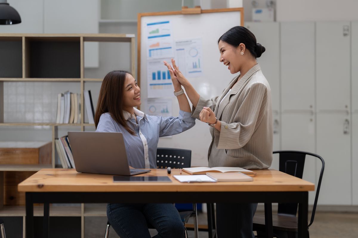 Two happy Asian women at the office