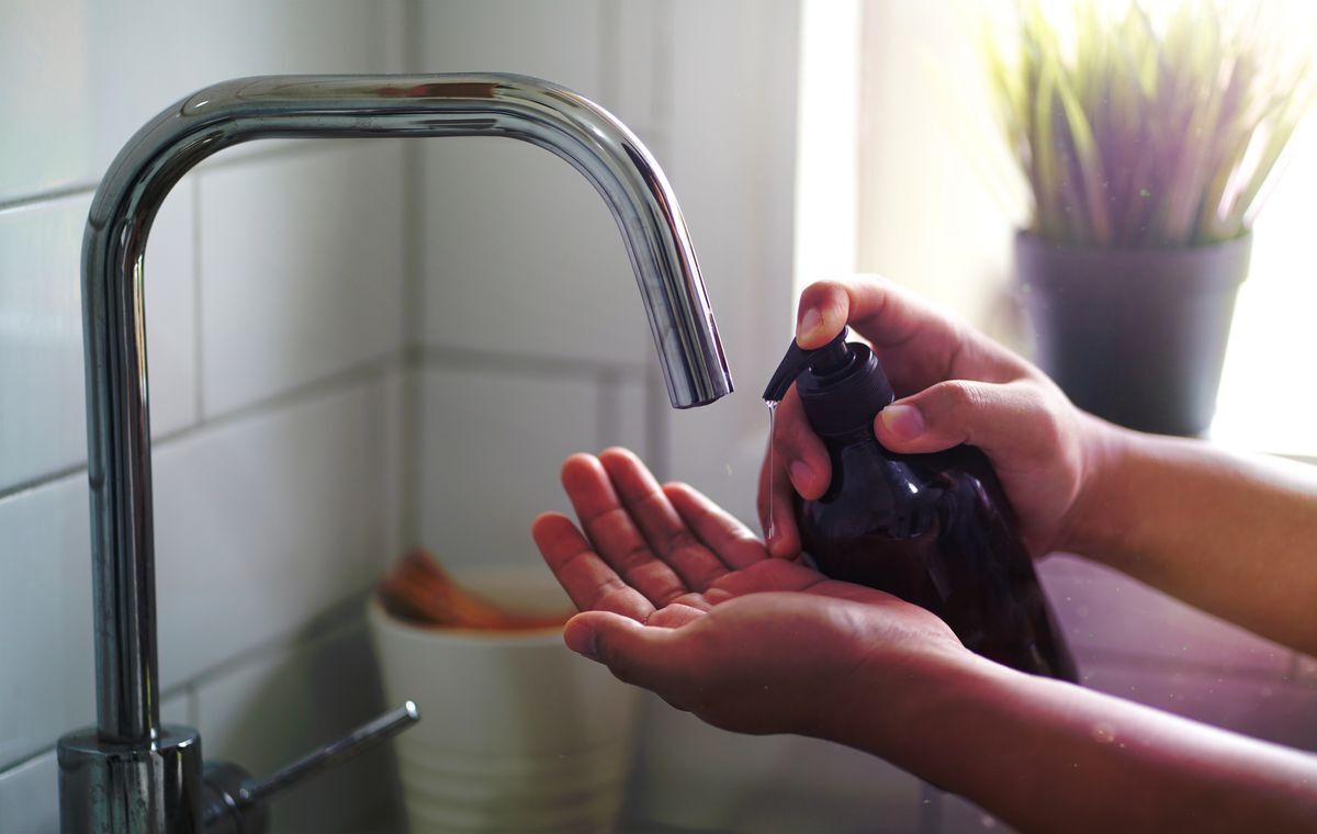 Hands of a man getting liquid soap. 