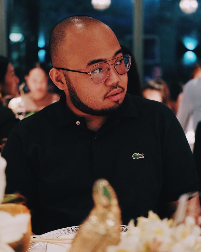 Asian man wearing glasses and a black shirt