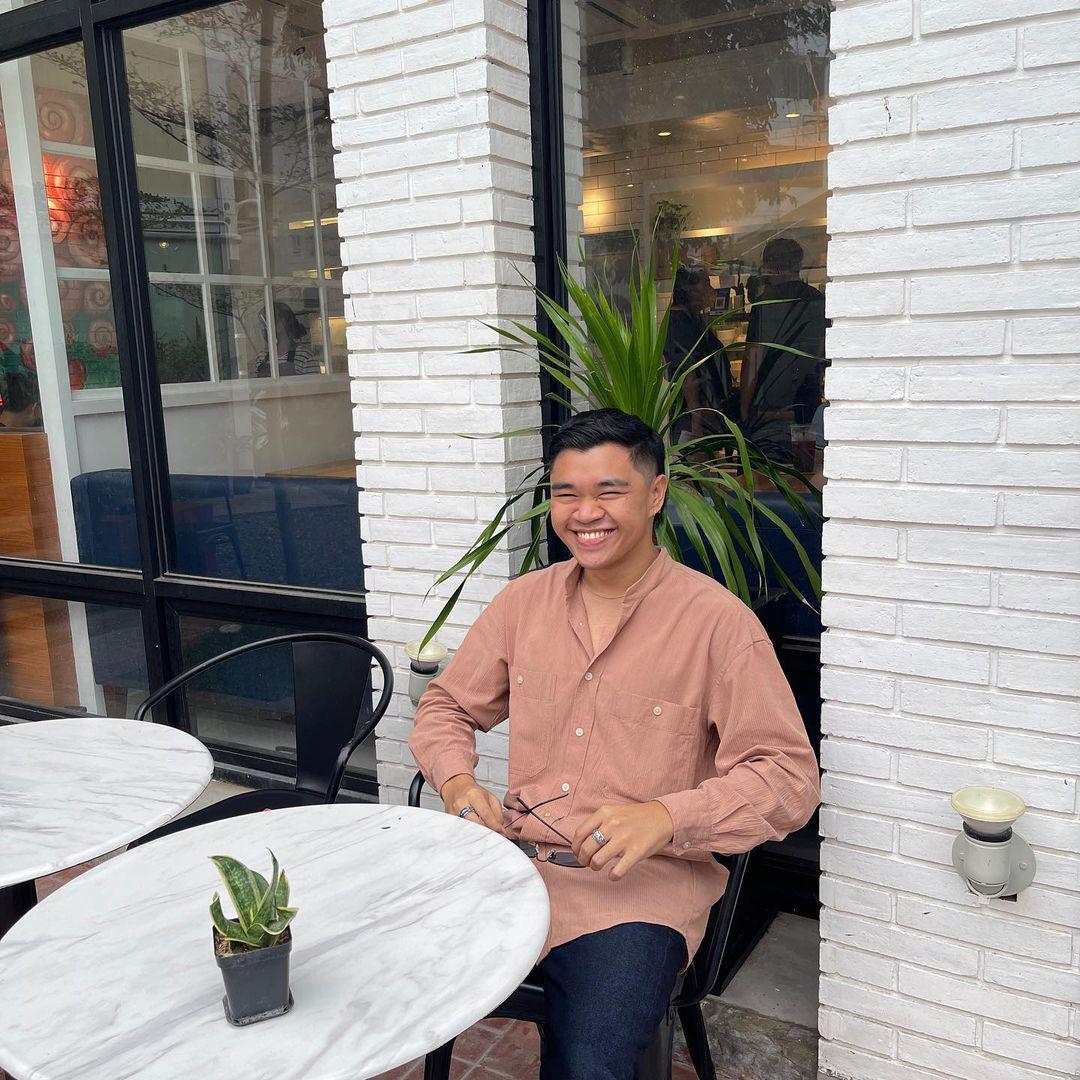 Asian man smiling outside a coffee shop