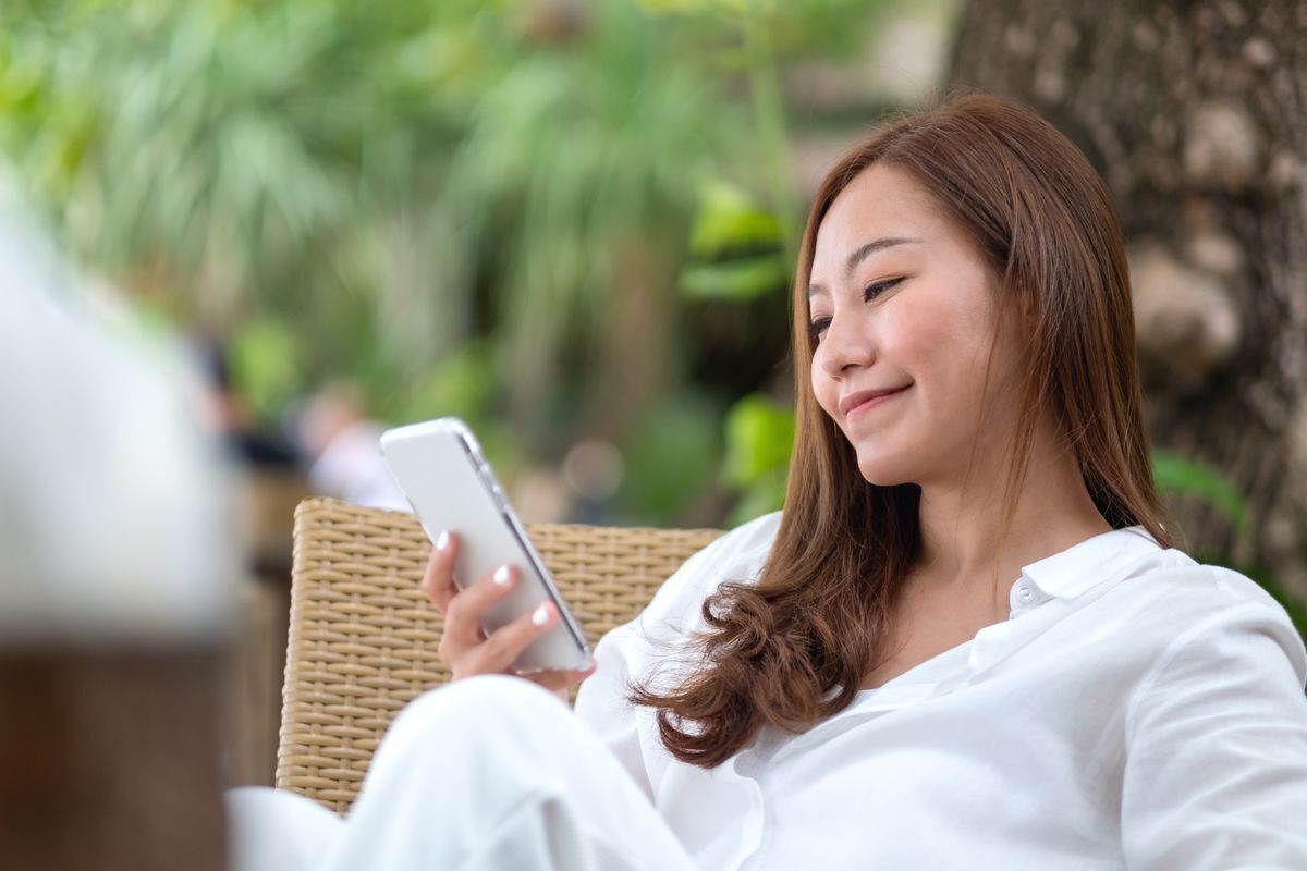 Asian woman wearing a white shirt relaxing