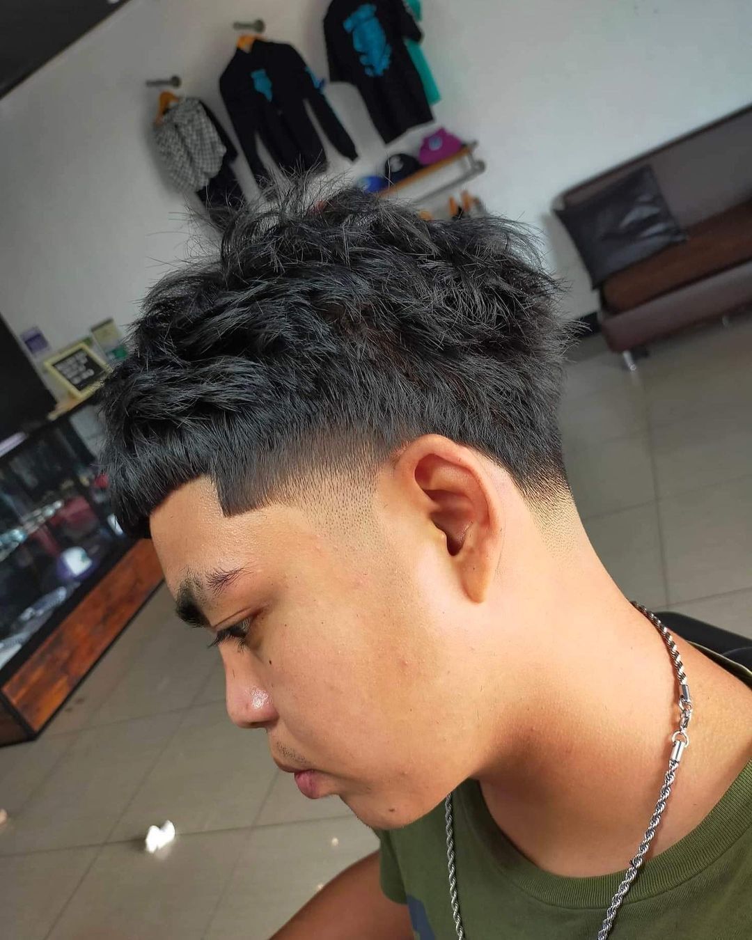 Man with black Edgar cut and eyebrow slits.