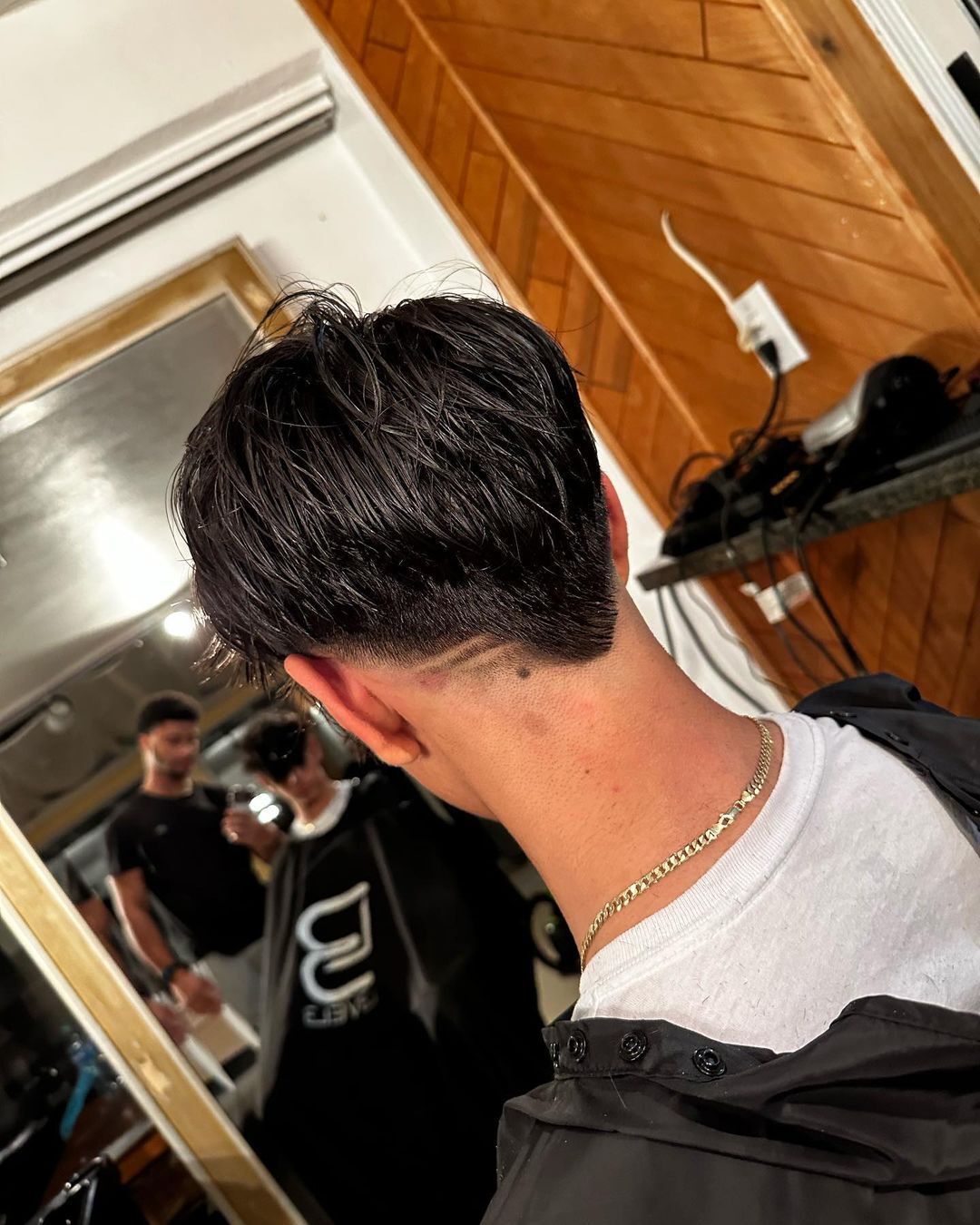 Man with V shaped drop fade and long bangs.