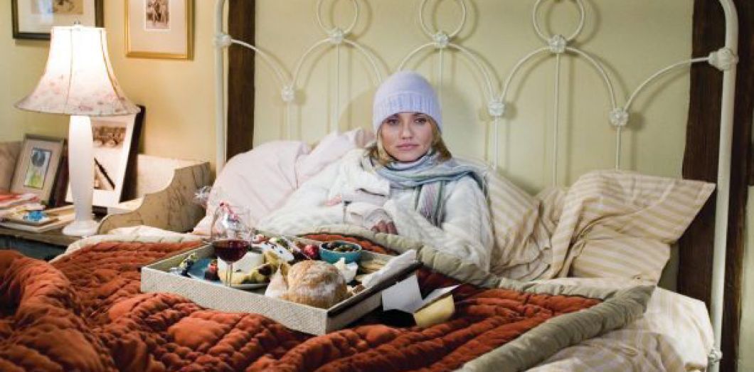 Cameron Diaz in The Holiday having treats and wine in a cozy bed.