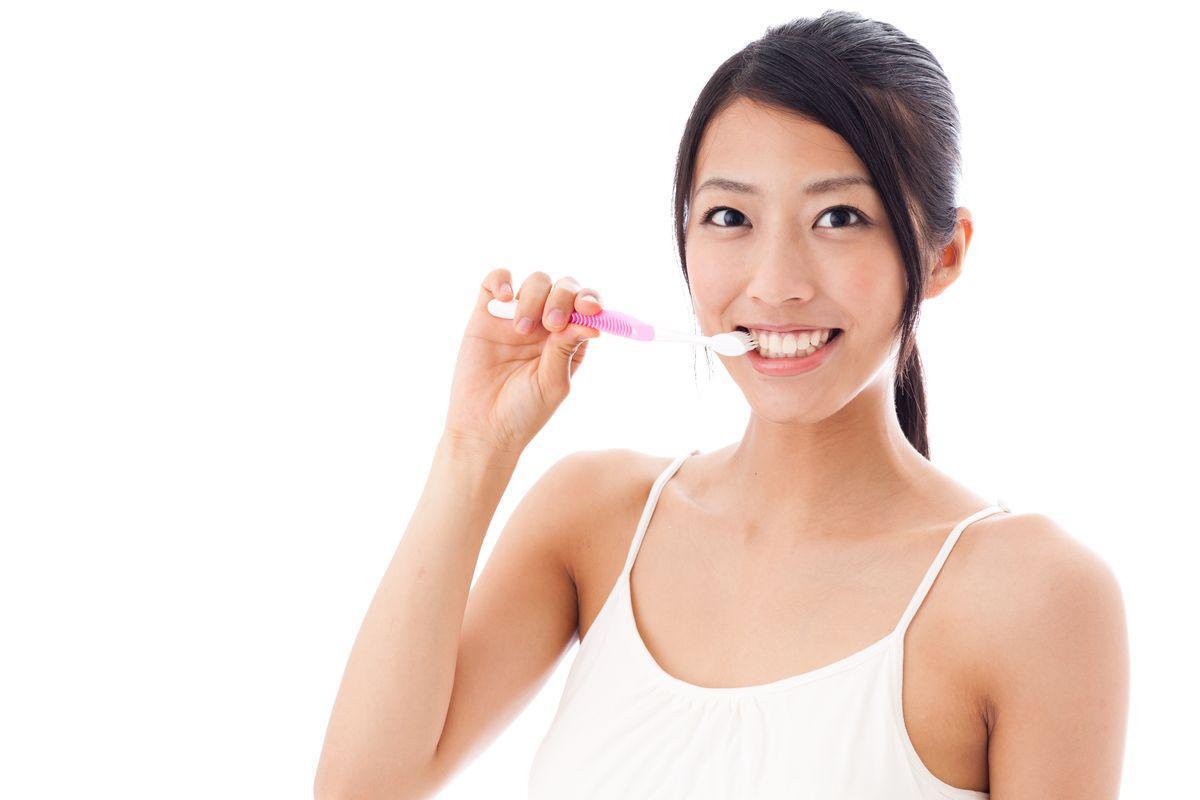 Asian woman brushing teeth