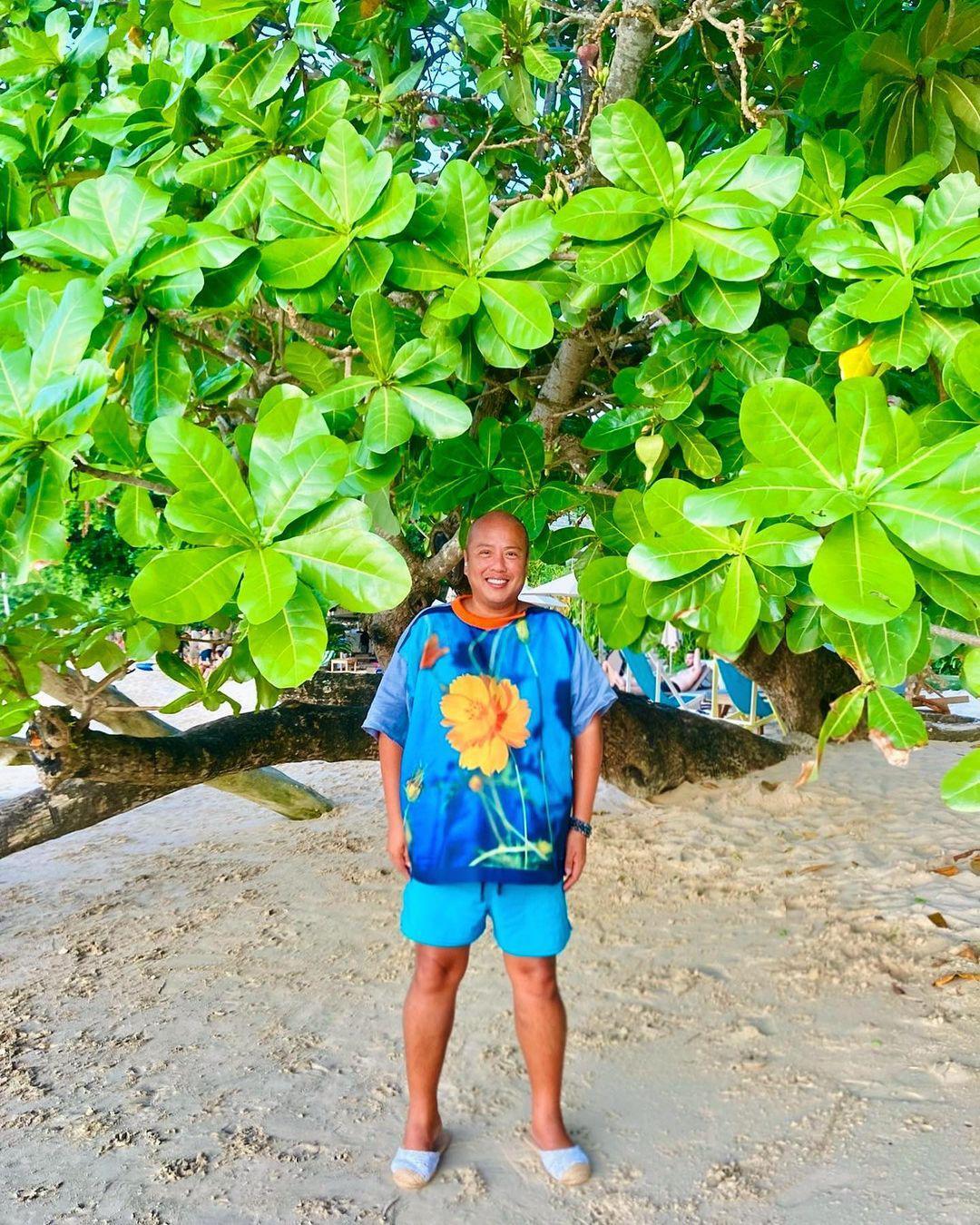 Man in a blue, floral shirt at the beach