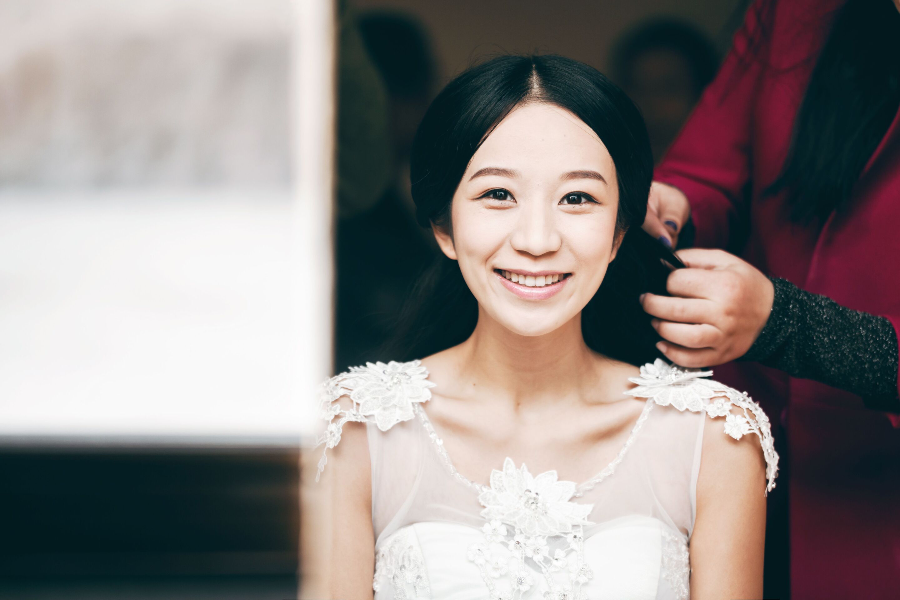 An Asian bride getting her hair done for her wedding