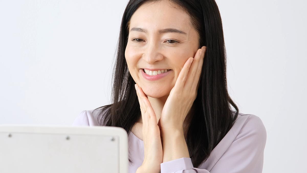 Elderly Asian woman holding face