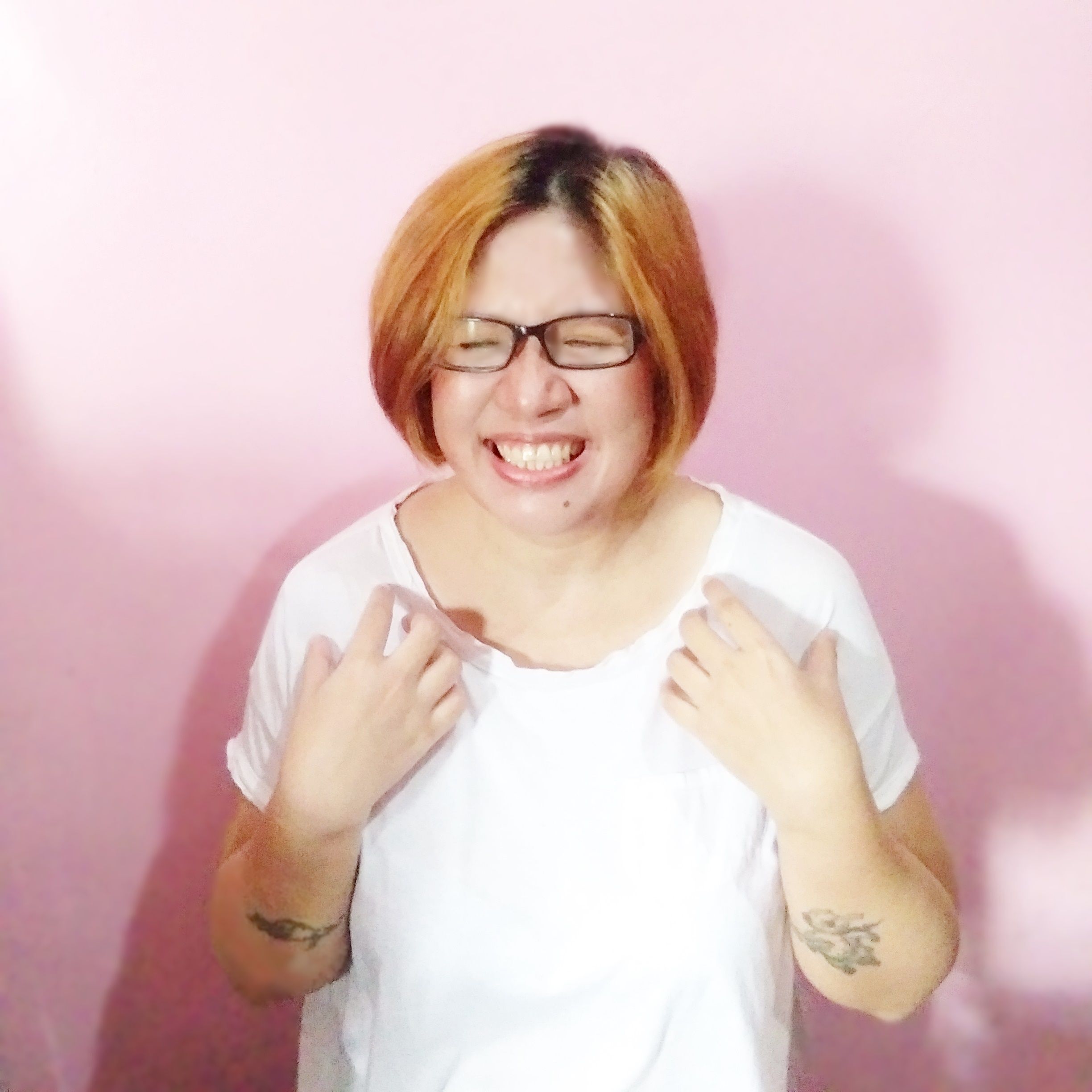 Asian woman in a white shirt with dyed hair and tattoos.