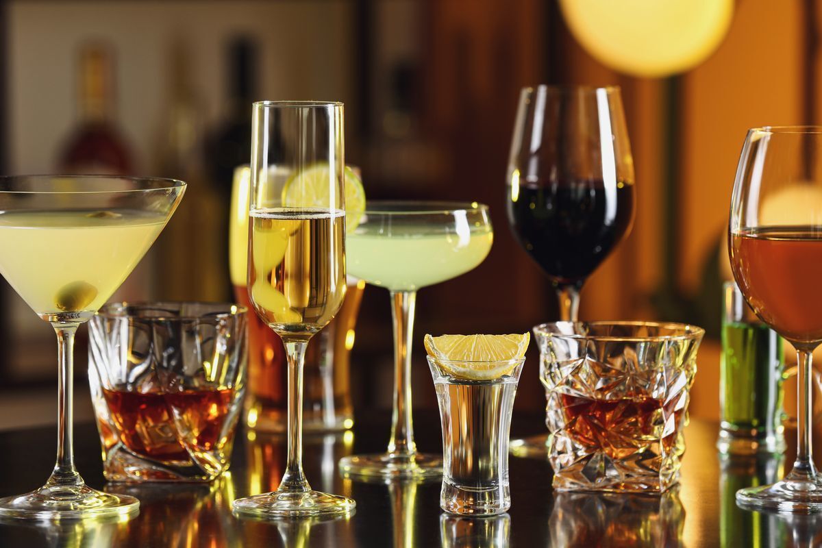 Various kinds of alcohol, from wine, whiskey, tequila, and champagne to martinis and gimlets, on a table bar