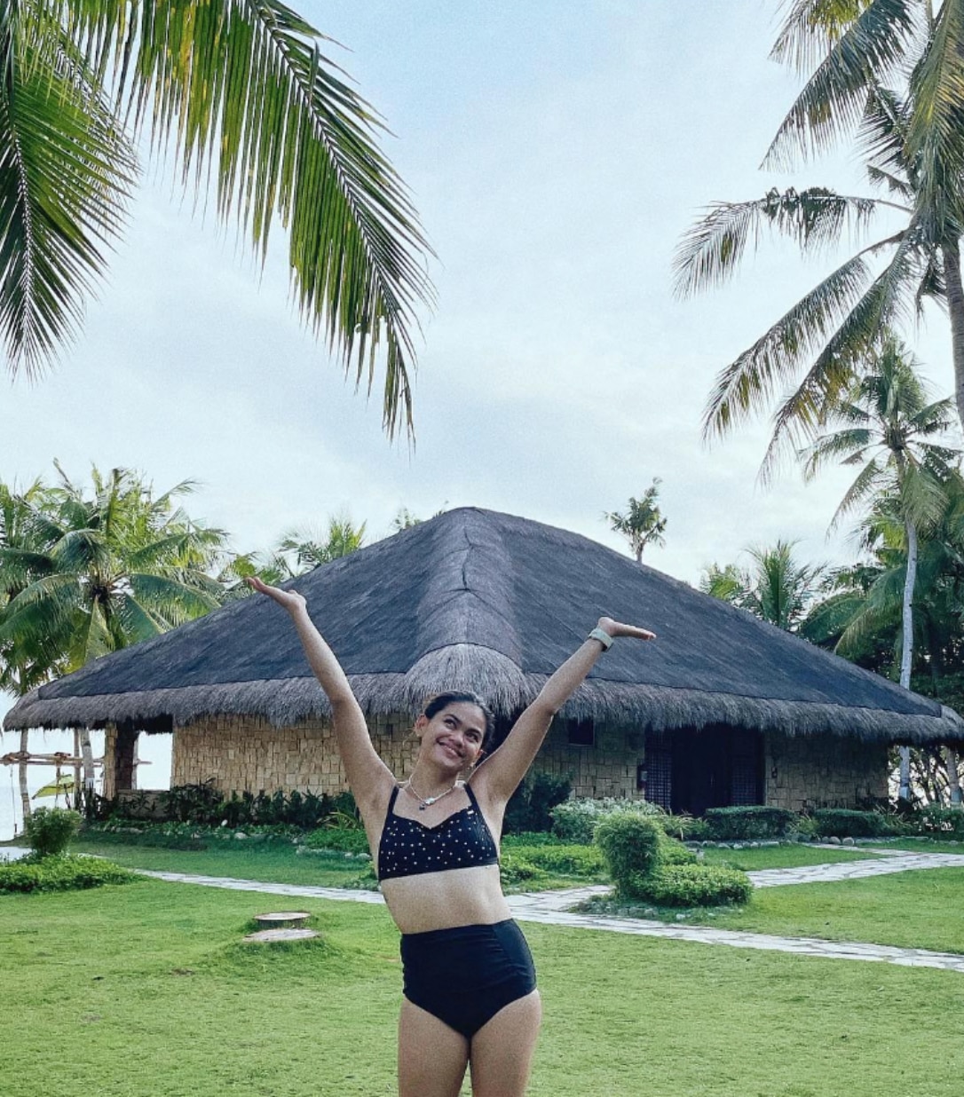 Woman posing in front of a beach hut