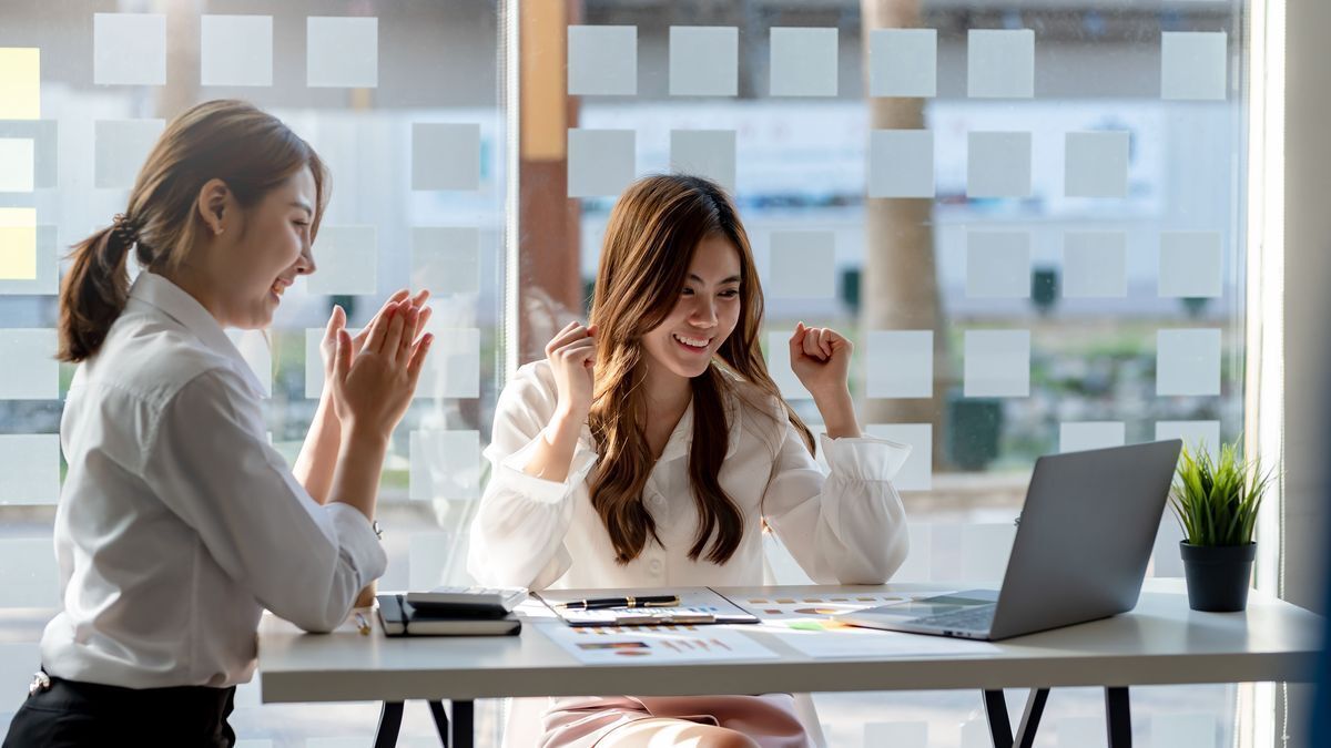 Two Asian woman celebrating at the office
