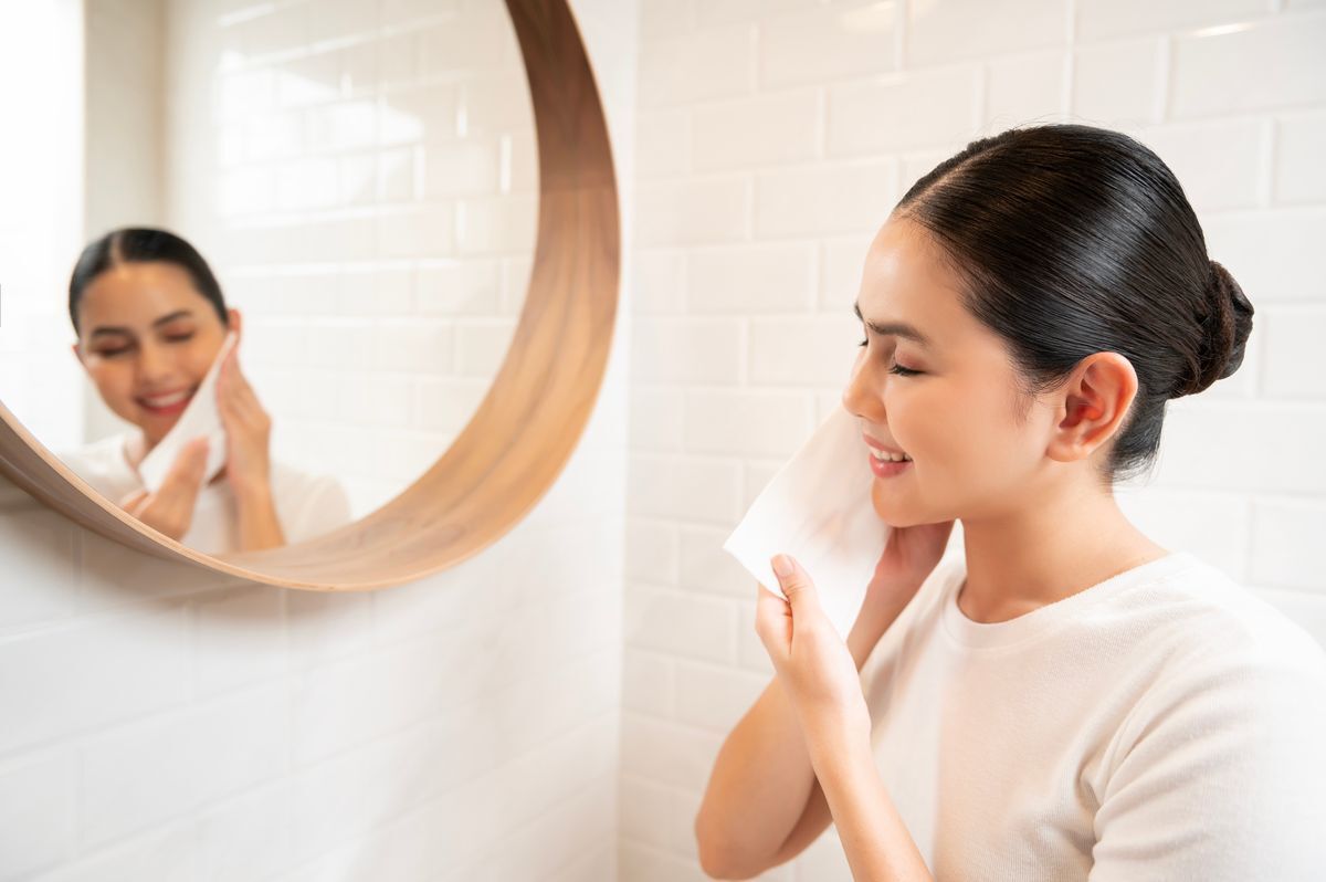 Woman drying her face with a clean, white towel.