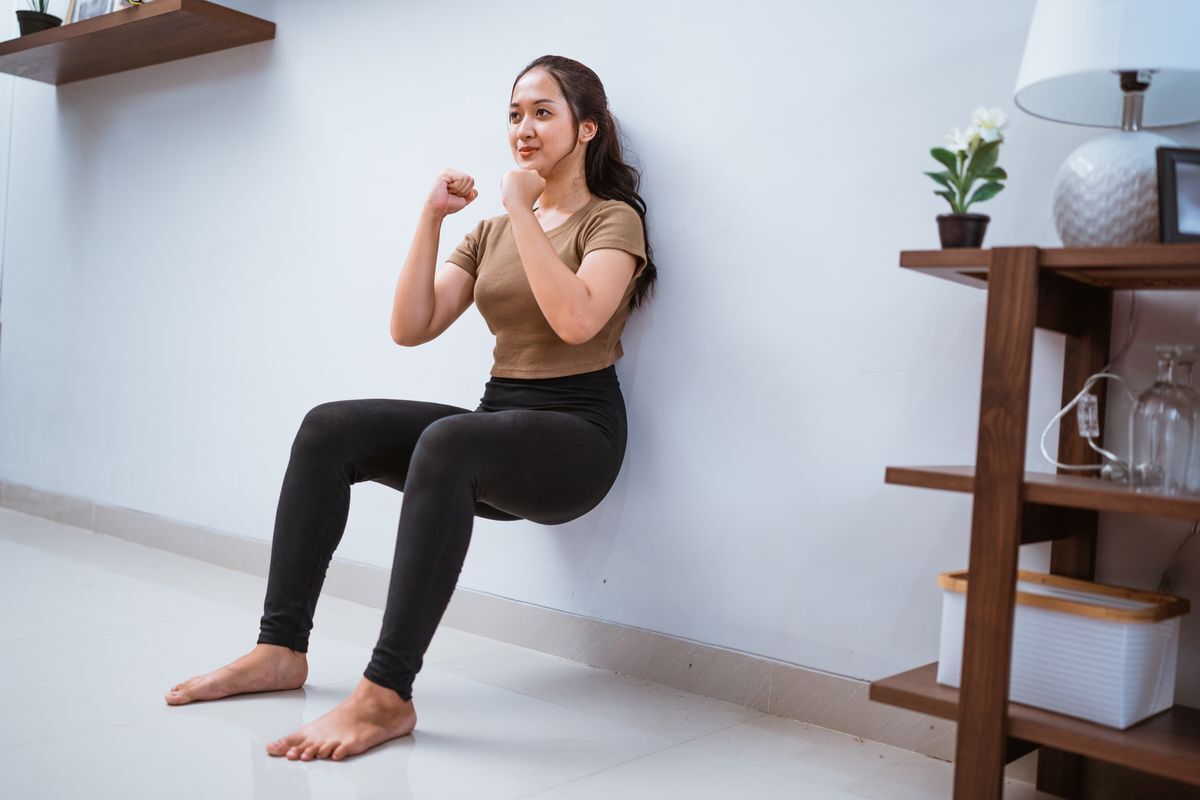 Woman squats against the wall