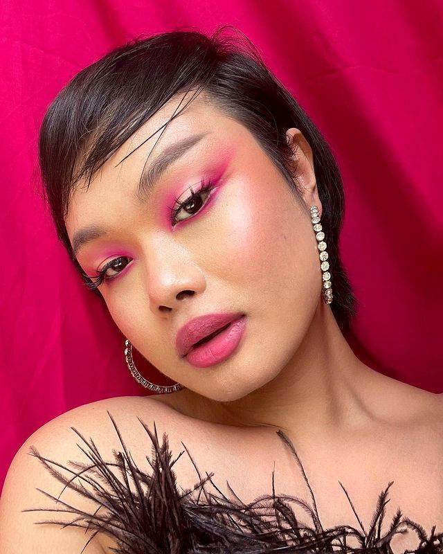 Woman in pink and gold eye makeup look.