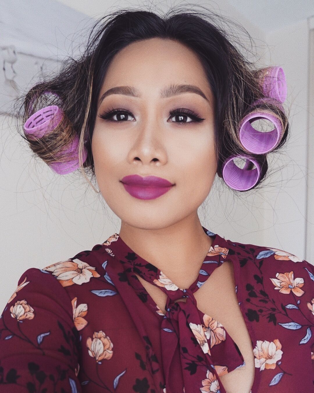 Woman purple hair rollers on both sides of her head. 