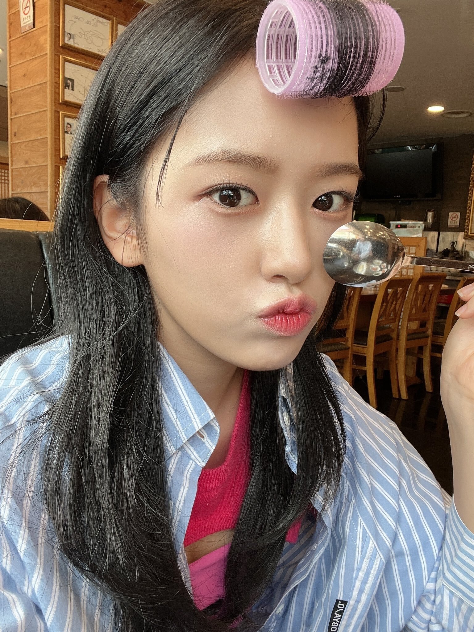 IVE’s Yujin with pink hair roller on her bangs.