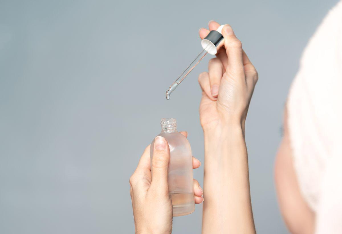 Asian woman holding serum for skin 