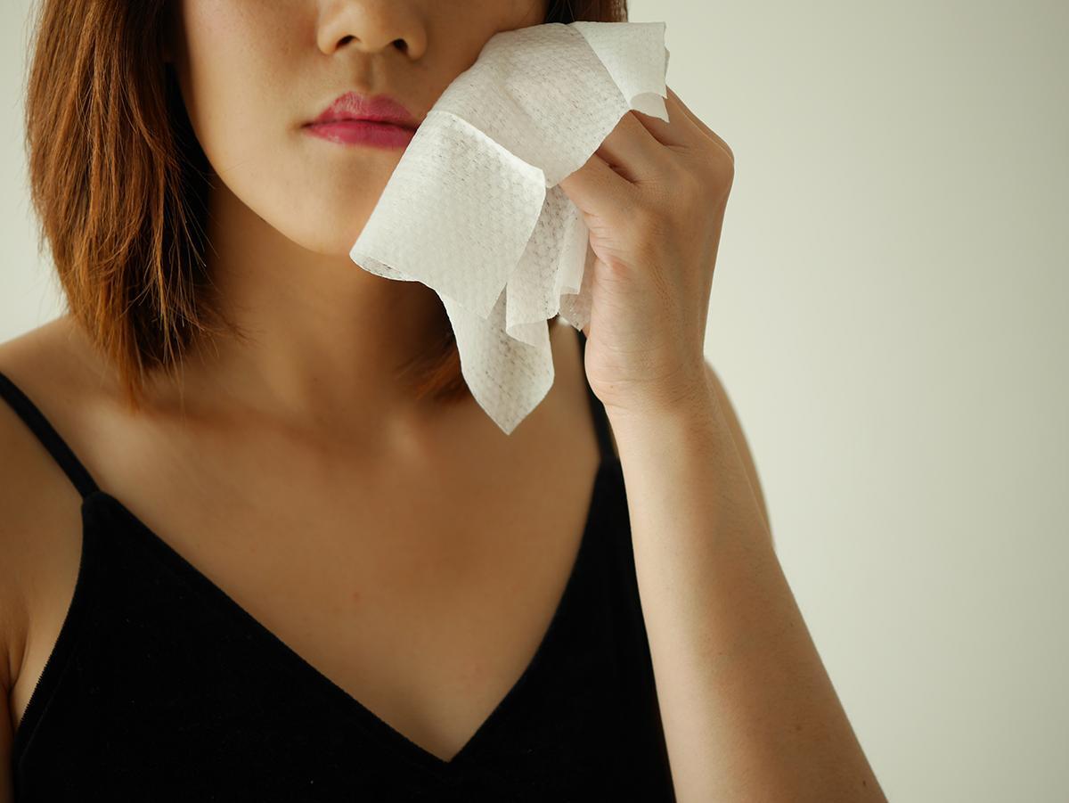 Woman removing makeup with wipes