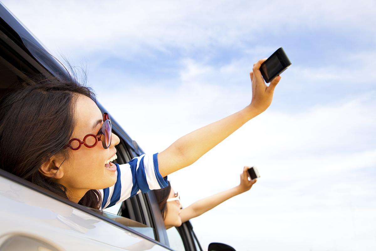 Young women taking selfies in a car