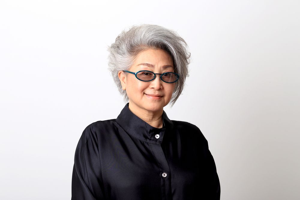 A woman with white hair wearing a black top